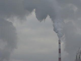 Industrial Smoke Pipe on a Grey Sky / Smoke air emissions from an CHP pipe on a grey sky in windless winter day