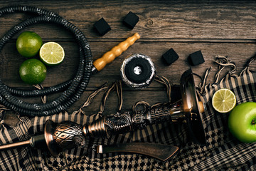 Dismantled parts of hookah on a wooden background with lime frui