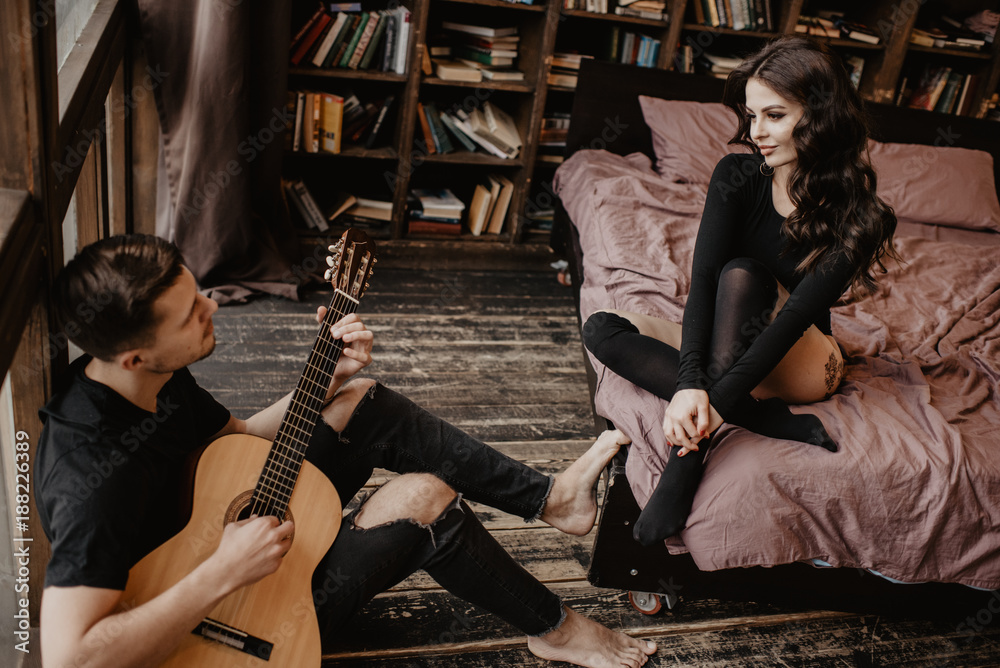 Wall mural beautiful sexy girl and her boyfriend playing guitar