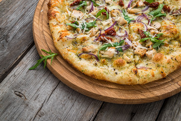 pizza with sun-dried tomatoes, prosciutto, arugula and parmesan cheese