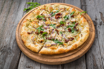 pizza with sun-dried tomatoes, prosciutto, arugula and parmesan cheese