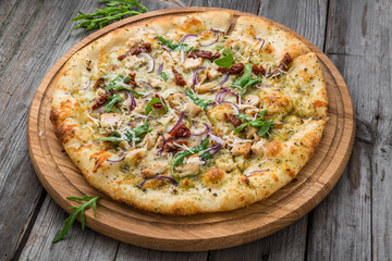 pizza with sun-dried tomatoes, prosciutto, arugula and parmesan cheese