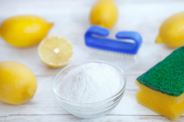 Fototapeta na wymiar Baking soda with lemon, brush and sponge