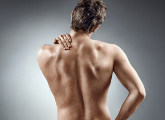 Young man holding his neck in pain. Medical concept.