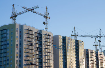 Fototapeta na wymiar Few cranes crane yellow finish building multi-storey