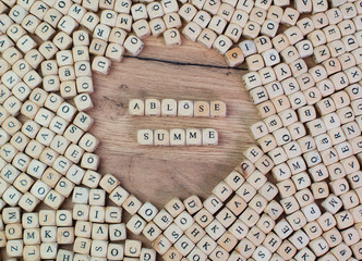 Ablösungssumme Buchstaben Würfel auf einem Holzbrett