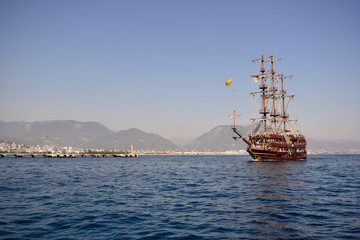 Fototapeta na wymiar Tourist yacht in the sea on the background of the coast.