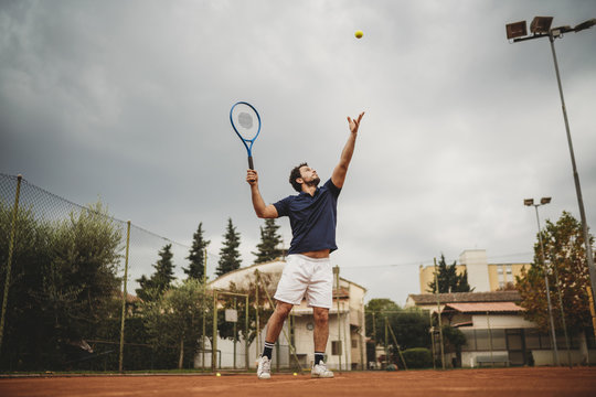 Young man engaged in the tennis service during a match