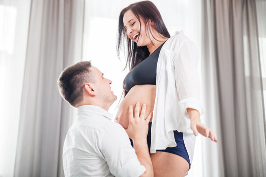 Happy father touching pregnant belly his wife, expecting baby