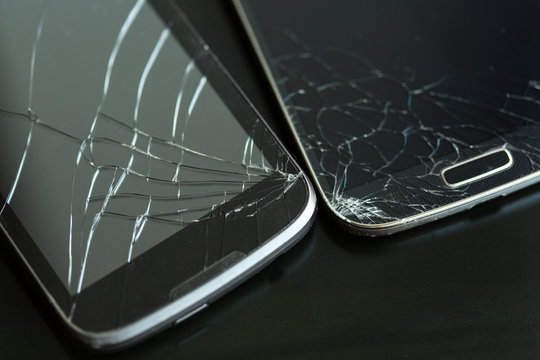 Two Smartphones with a broken display. Cracked Glass screen.