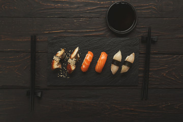 Sushi and rolls set in japanese restaurant on black wood