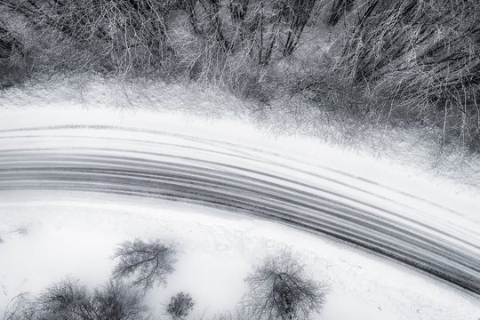 Aerial View Of Snowy Forest With A Road