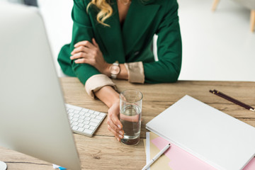 Fototapeta premium cropped shot of businesswoman holding glass of water at workplace