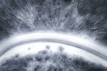 Aerial view of snowy forest with a road