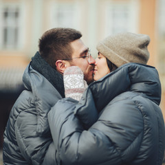 Fototapeta premium Classy groom and his gorgeous bride pose outside in winter coats 