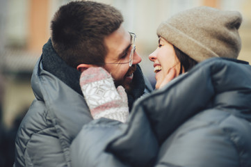 Fototapeta premium Classy groom and his gorgeous bride pose outside in winter coats 