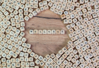 Wellness Buchstaben Würfel auf einem Holzbrett
