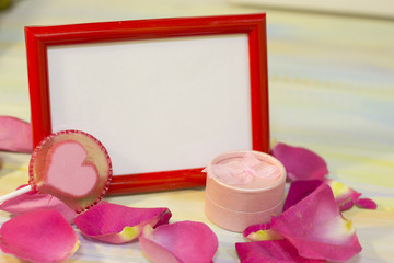 The concept of Love, Wedding, Proposal, Anniversary, St. Valentine's Day with a red photo frame, pink jewellery box, lolipop candy and rose petals, light background