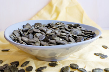 fresh pumpkin seeds in ceramic plate