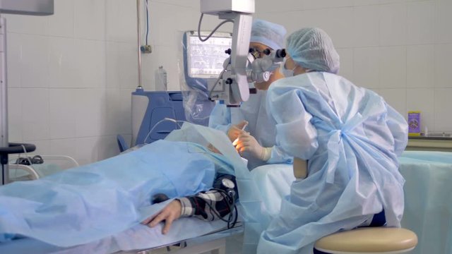 A lying patient under a large microscope during surgery. 