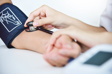 Female doctor measuring blood pressure.