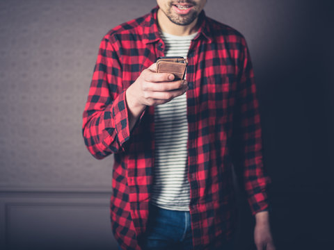 Young man in flannel shirt is using smart phone