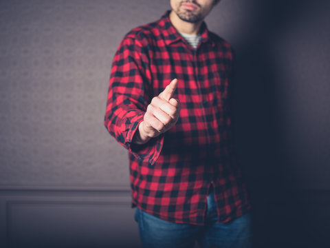 Man in flannel shirt pointing