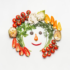 Fototapeta na wymiar Healthy lifestyle concept. Funny face made with various vegetables ingredients on white background, top view, frame. Detox, dieting and clean eating food