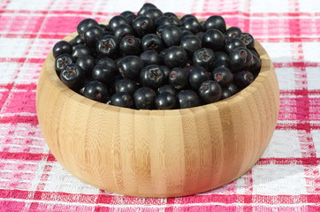 Black Chokeberry (aronia melanocarpa) in a bamboo bowl on the table