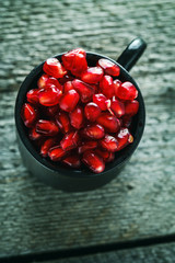 Ripe pomegranate seeds in a small cup