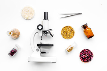 Fototapeta na wymiar Food safety. Wheat, rice and red beans near microscope on white background top view