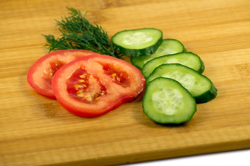 Tomato, cucumber and dill on a wooden board