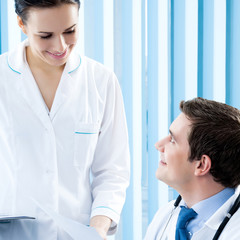 Two happy medical people working together at office