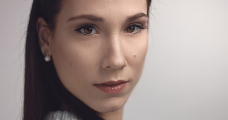 Naklejka premium closeup of spanish woman looking at camera on grey background