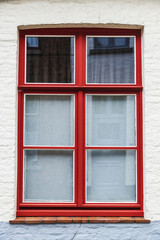 Red window of an old classic building in Bruges, Belgium