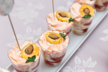 luxury wedding catering, table with modern desserts, cupcakes, sweets with fruits.