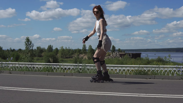 young girl in shorts and tops skates on roller skates