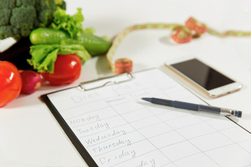 Vegetables, measuring tape, cell phone, diet plan