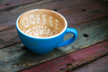 Coffee written in foam in blue cup