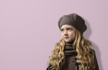 A girl in a knitted cap and scarf .