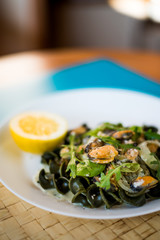 Black pasta with seafood in white cream sauce and lemon