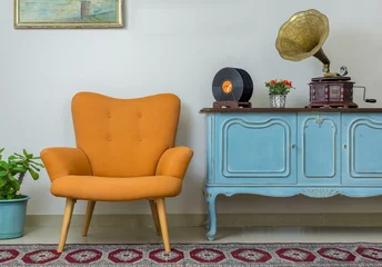 Fotobehang Vintage interior of retro orange armchair, vintage wooden light blue sideboard, old phonograph (gramophone), vinyl records on background of beige wall, tiled porcelain floor, and red carpet © Khaled El-Adawi