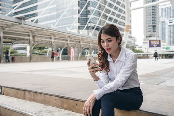 Fototapeta premium Asian business woman is holding and using phone.