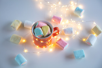 Cup of coffee with marshmallows and fairy lights