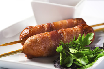 Fried sausages rolled in bacon