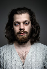 Portrait of a handsome man with a beard, long hair and big blue eyes