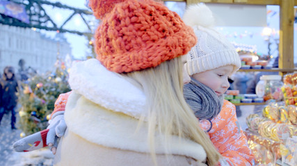 Mother and her little son are enjoying winter holidays at the Christmas fair