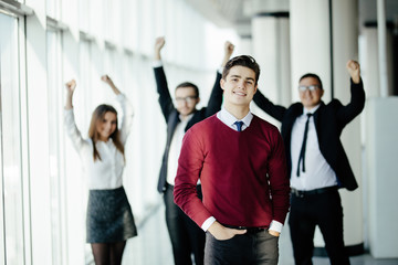 handsome business man in front of his team member celebrating their achievement in office