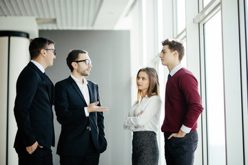 Fototapeta premium Businesspeople Having Informal Meeting In Modern Office on windows background