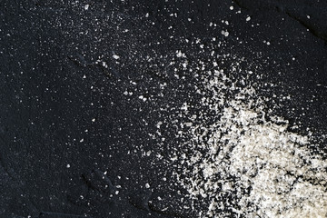 Sea salt strewn on a black background